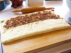 Pecan roll dough with one edge folded.