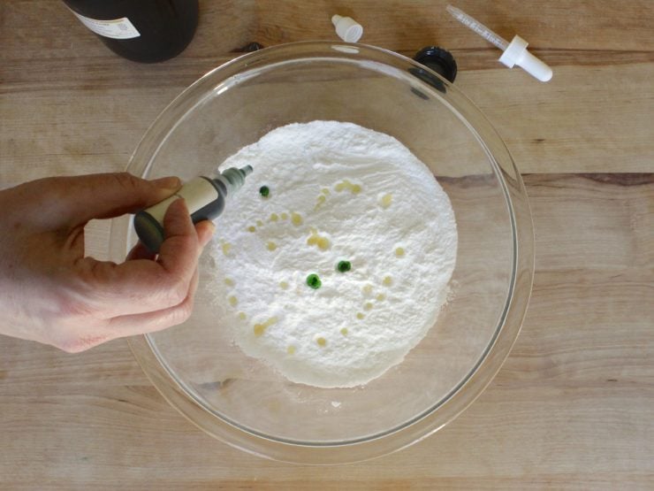 Adding coloring to dry ingredients in glass mixing bowl. 