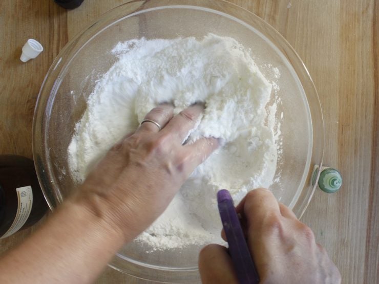 Mixing dry ingredients in mixing bowl with hands.