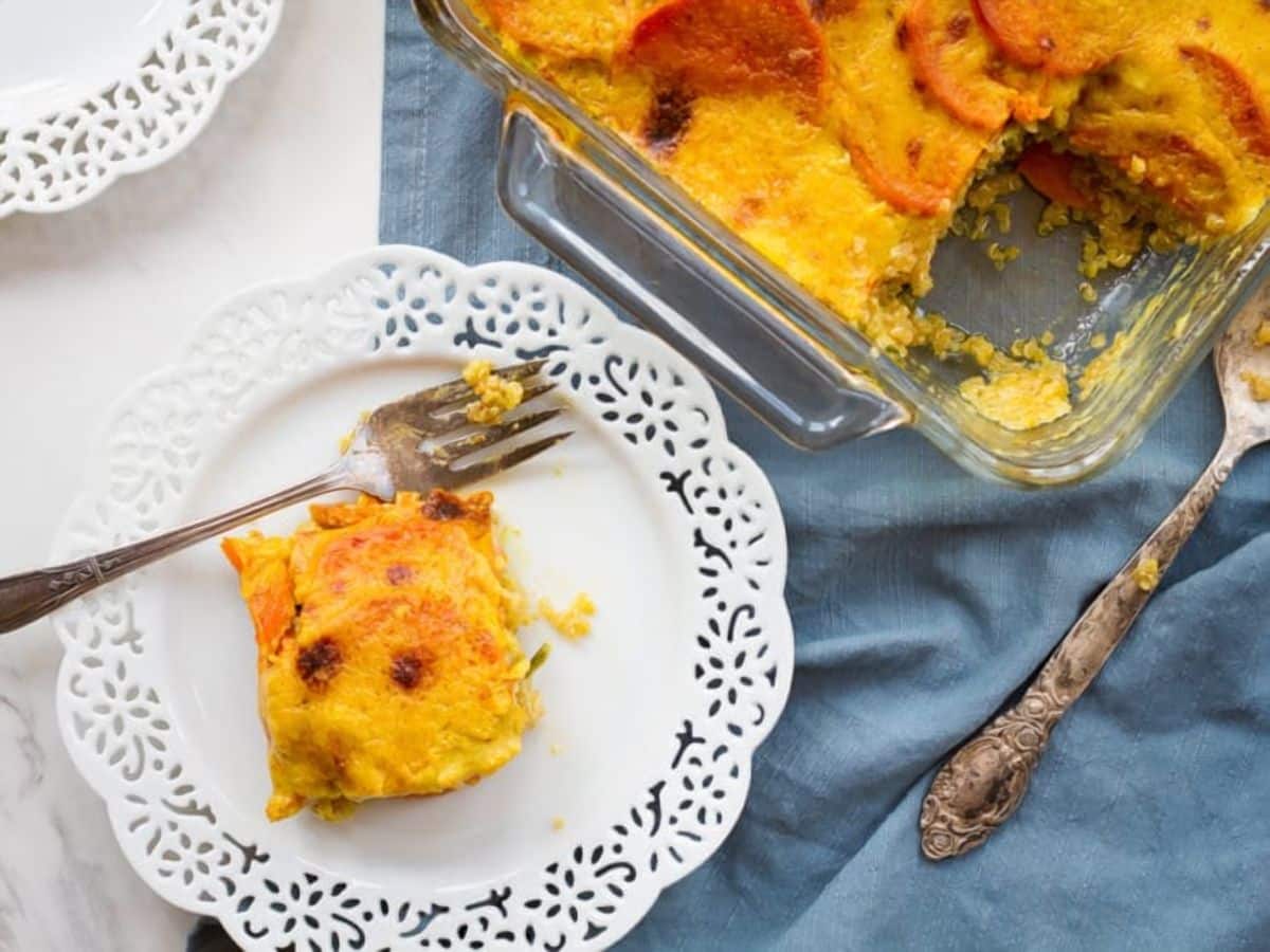 A plate with a fork holds a slice of carrot casserole, topped with sweet potato quinoa