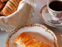 Flaky pastries filled with sweet apples with jam and a cup of coffee