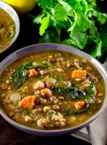 A bowl of lemon lentil soup with spinach and carrots