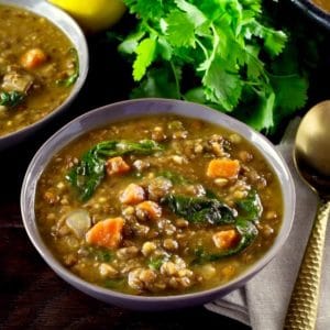 A bowl of lemon lentil soup with spinach and carrots