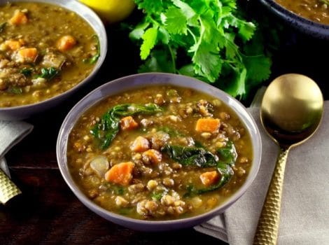 A bowl of lemon lentil soup with spinach and carrots