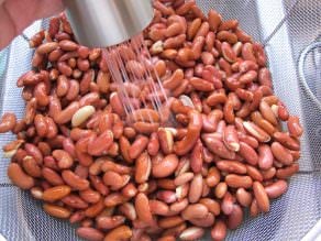 Kidney beans being washed in a colander
