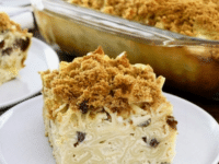 A plate of Pineapple Raisin Noodle Kugel, a casserole dish topped with crumbs