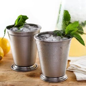 Close-up of two Sparkling Lemon Mint Juleps glasses with ice and topped with a Mint leaves