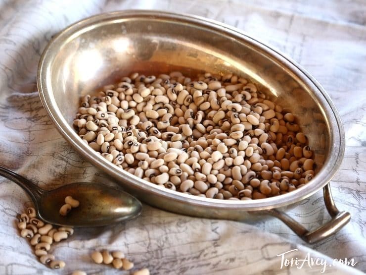 Dried black eyed peas in metal bowl with spoon.