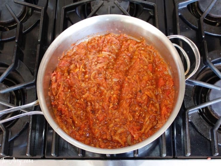 Tomato reduction sauce in saute pan on stovetop.