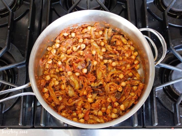 Mnazaleh cooking in saute pan with chickpeas and eggplant pieces.