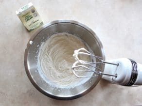 Freshly whipped cream in bowl with mixer on white background with Clover Sonoma heavy whipping cream.
