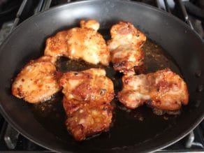 Spicy Teriyaki Broiled Chicken Thighs in skillet with olive oil fresh out of the oven.