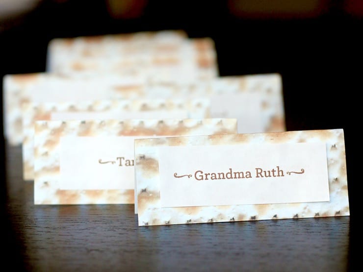 Matzo paper name tags lined up on tabletop - first name tag says Grandma Ruth