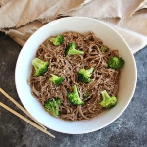 Overhead shot of Citrus Tahini Soba Noodles & Broccoli with chopsticks and cloth.