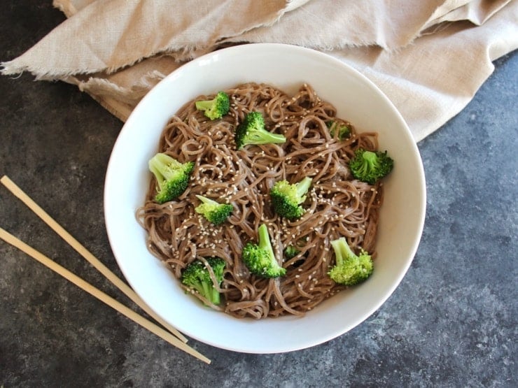 Overhead shot of Citrus Tahini Soba Noodles & Broccoli with chopsticks and cloth.