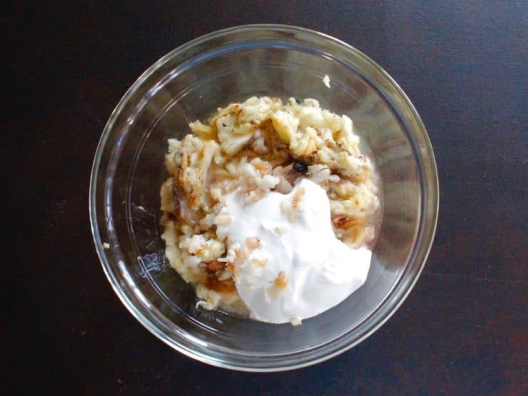 Roasted eggplant, roasted garlic, tahini and Greek yogurt in glass bowl.