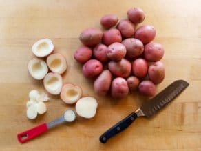 Overhead view of small red potatoes. Some are whole and others are cut in half with the center scooped out.