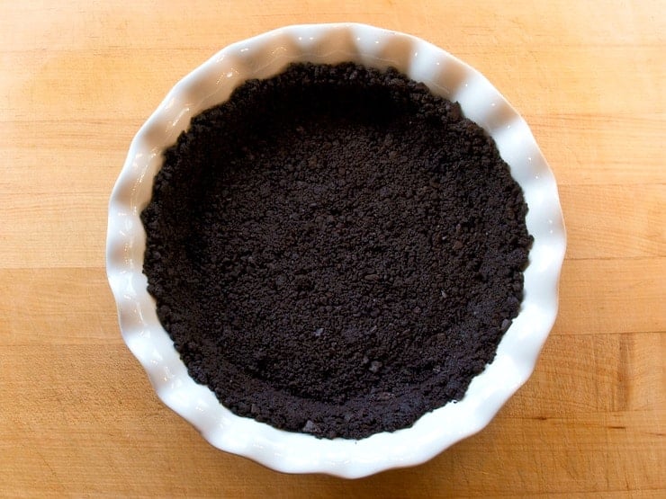 Chocolate pie crust in a white circular pie pan.