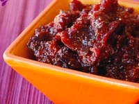 Homemade cranberry sauce with a touch of Spiced Fig Preserves on an orange bowl