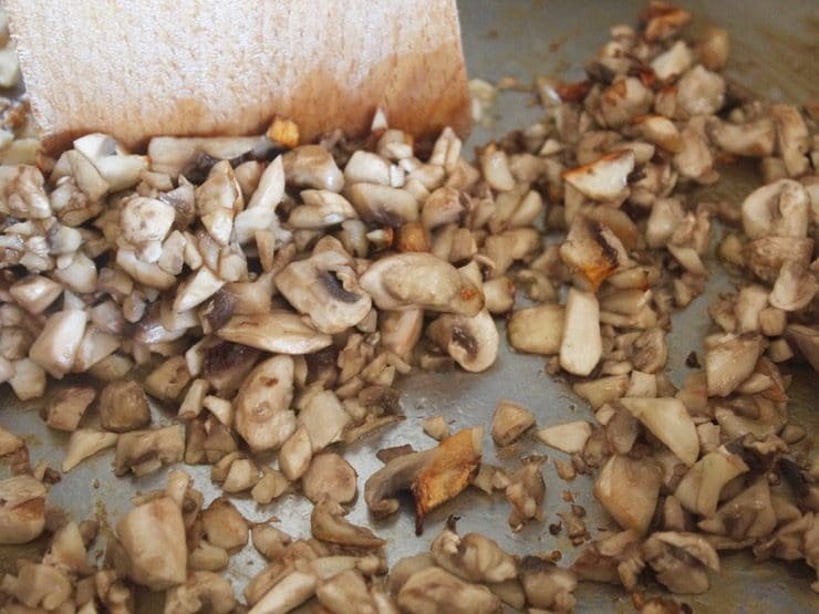 Close up of chopped mushrooms in pan, searing golden brown