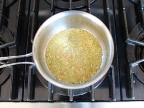 Minced onion in saucepan with garlic, cooked to translucent and starting to turn golden.
