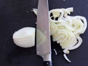 Slicing fennel bulb into thin slices.