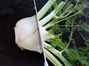 Slicing stalks from fennel bulb.