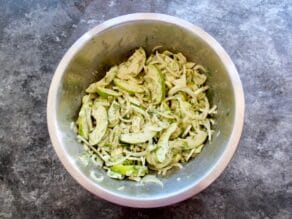 Bowl of apple slices, fennel slices and fennel fronds.