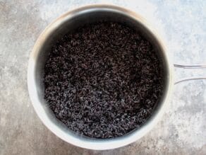 Overhead shot of black rice in a metal mixing bowl.