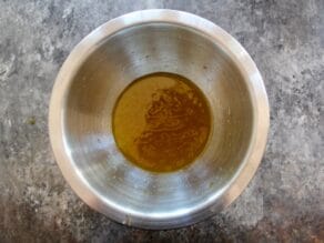 Overhead shot of lemon honey salad dressing in a metal mixing bowl.