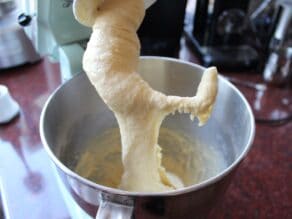 Sufganiyot dough in a mixer, stretched and flexible on hook attachment.