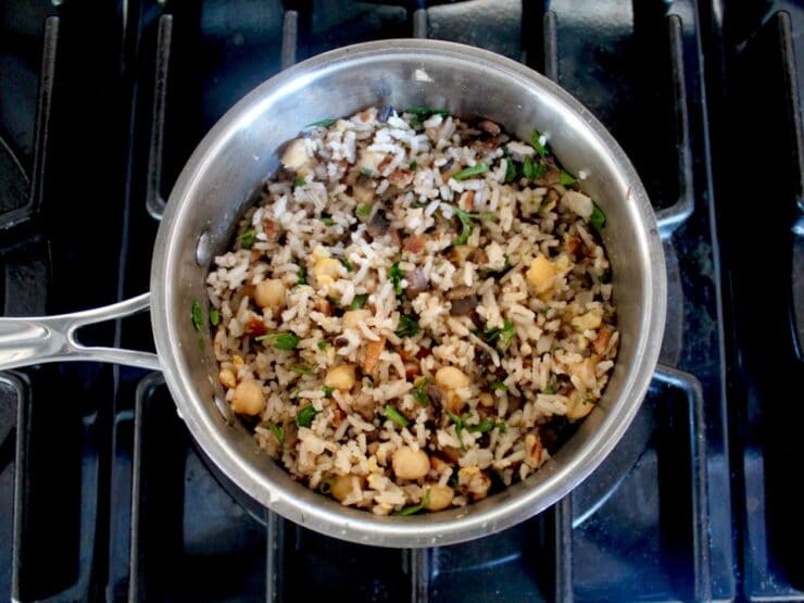 Overhead horizontal shot of vegan stuffed acorn squash filling in small saucepan on stovetop.