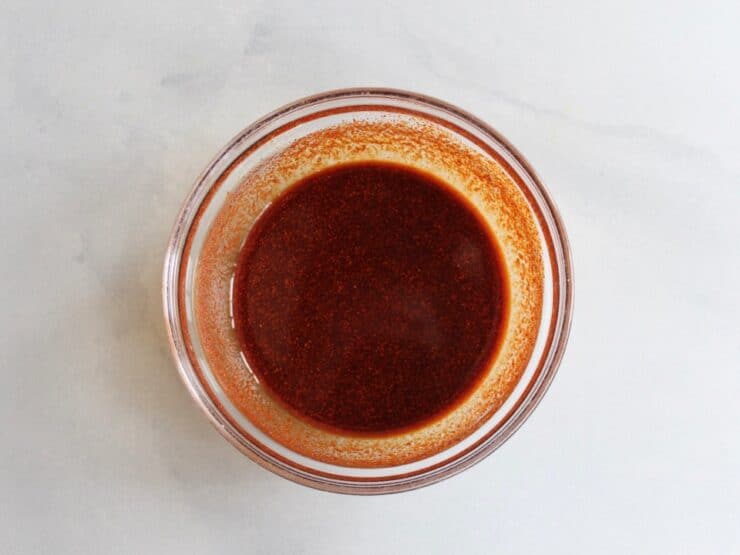 Small glass bowl with liquid paste made from smoked paprika, garlic powder and salt.