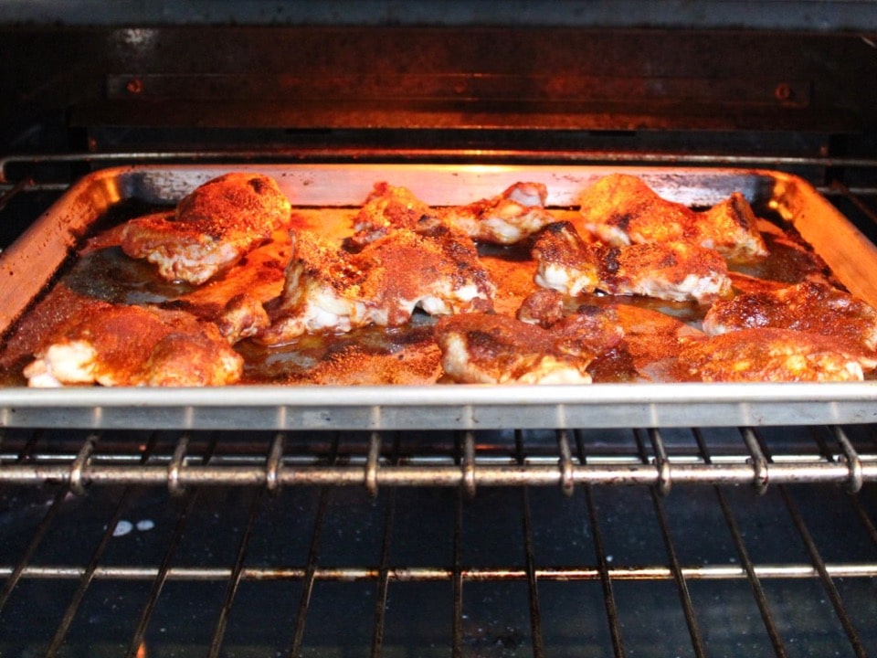 Tray of Smoked Paprika Chicken Thighs cooking in oven under the broiler