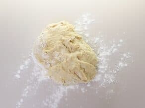 Overhead shot of challah dough on a floured surface.