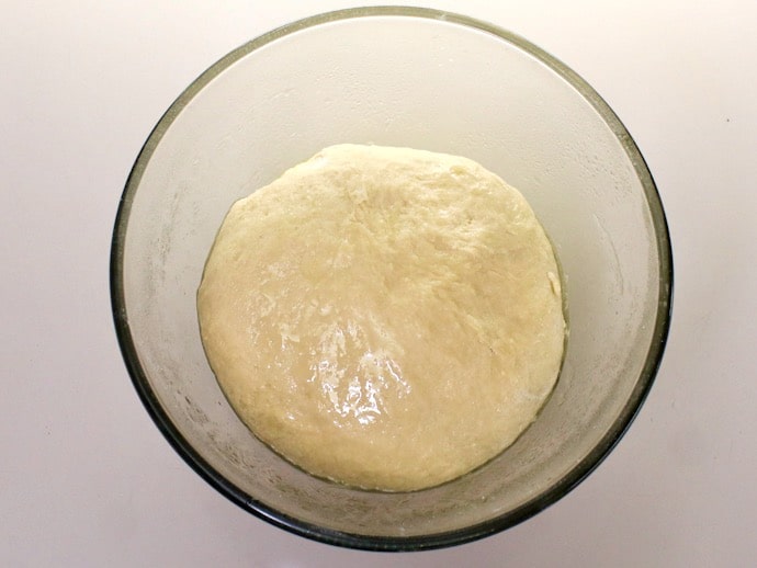 Overhead shot of smooth challah dough in a mixing bowl.