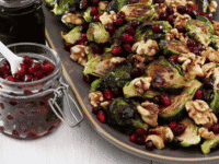 A plate of roasted brussels sprouts with cranberries, walnuts, and pomegranate molasses