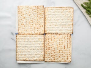 Horizontal overhead shot of four sheets of matzo laying in a square formation.