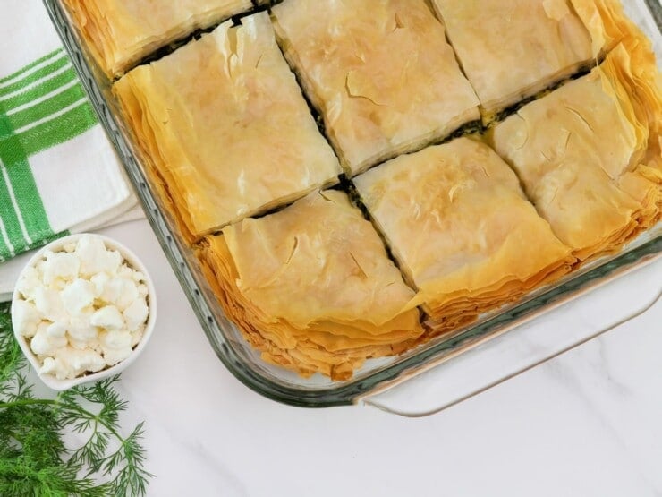 Horizontal close up shot of spanakopita in a glass baking dish.