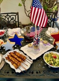 Festive 4th of July table set with healthy, delicious grilled food and seasonal side dishes.