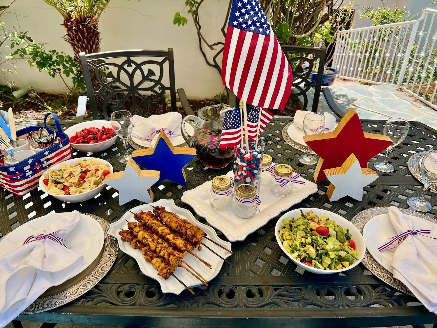 Festive 4th of July table set with healthy, delicious grilled food and seasonal side dishes.