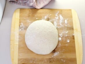 Ball of dough on a floured cutting board.