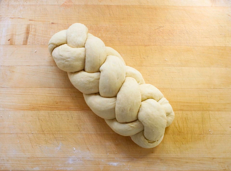 Braided dough resting on a wooden table.