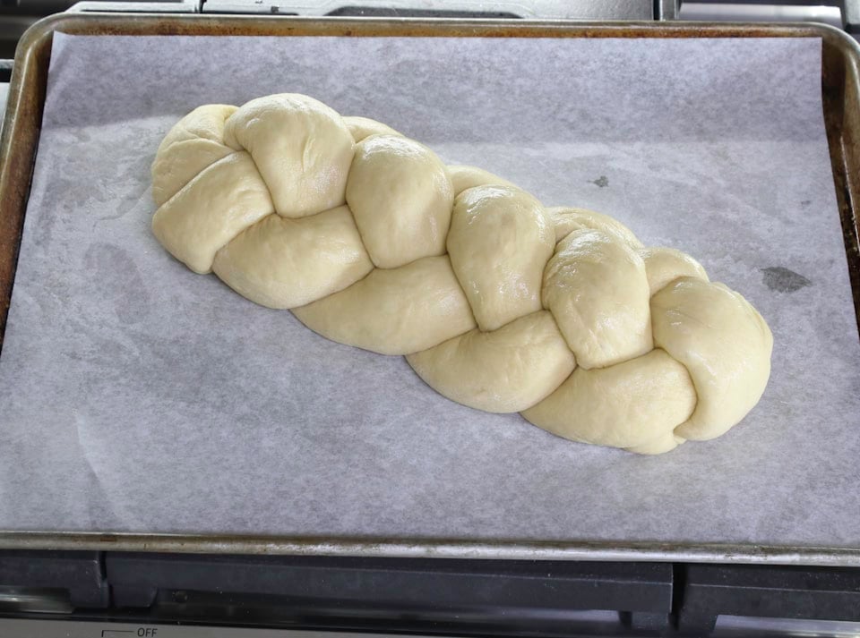 Braided dough resting on a baking sheet, ready for baking.