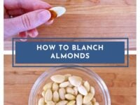 How to Blanch Almonds Pinterest Pin - top, fingers pinching an almond from its skin, with skinned and whole almonds scattered below on a cutting board. Bottom, a glass dish of skinned blanched almonds.