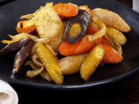 Spicy Roasted Carrots and Fennel Pinterest Pin - A black plate with colorful roasted carrots and fennel garnished with herbs.